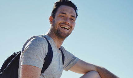 A man with a backpack smiling